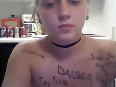 Ponytailed blonde girl writes all kinds of words on her naked body in the kitchen tube porn video